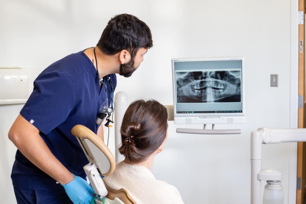 Dr. Nil Amin and a female patient looking at a dental x-ray