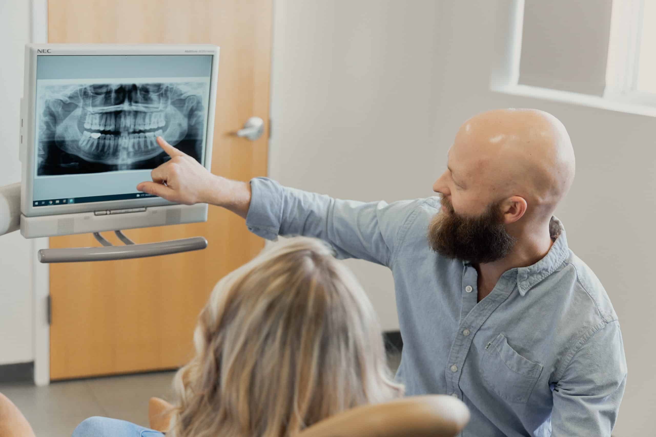 Dr. Joel Butterworth showing a female patient an x-ray of teeth