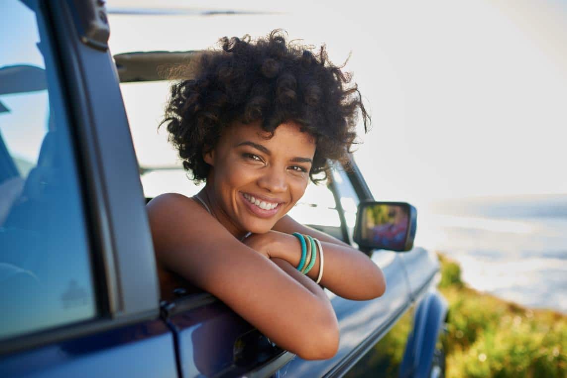 Woman smiling while leaning out of a car window