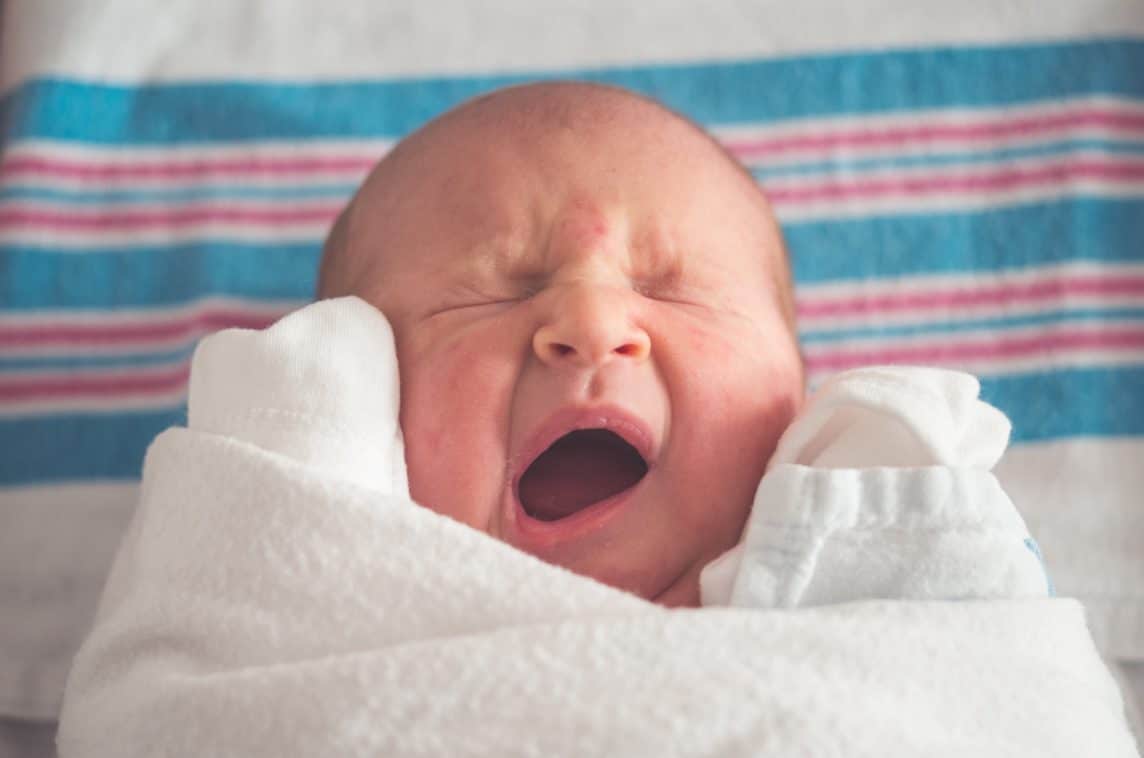 Baby yawning with eyes closed