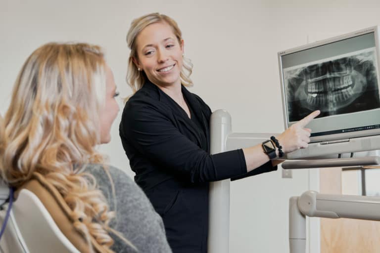 Hygienist showing female patient a tooth x-ray