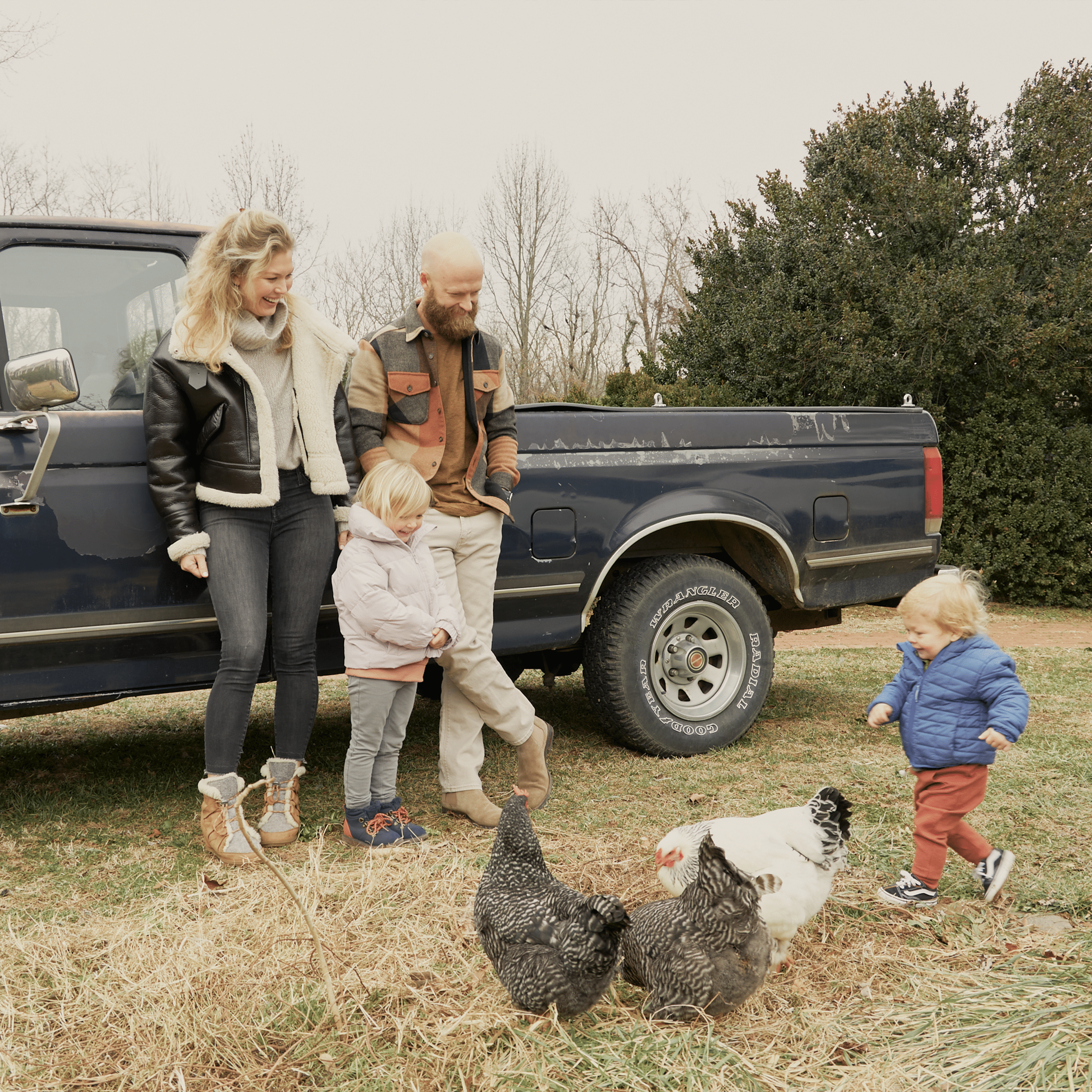 Dr. Joel Butterworth and his family playing with chickens